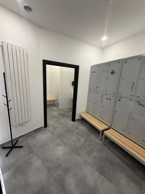 Męska szatnia z szafkami, ławką i wieszakami